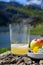 Green bottle and glass of natural Asturian cider made fromÂ fermented apples with view on Covadonga lake and tops of Picos de